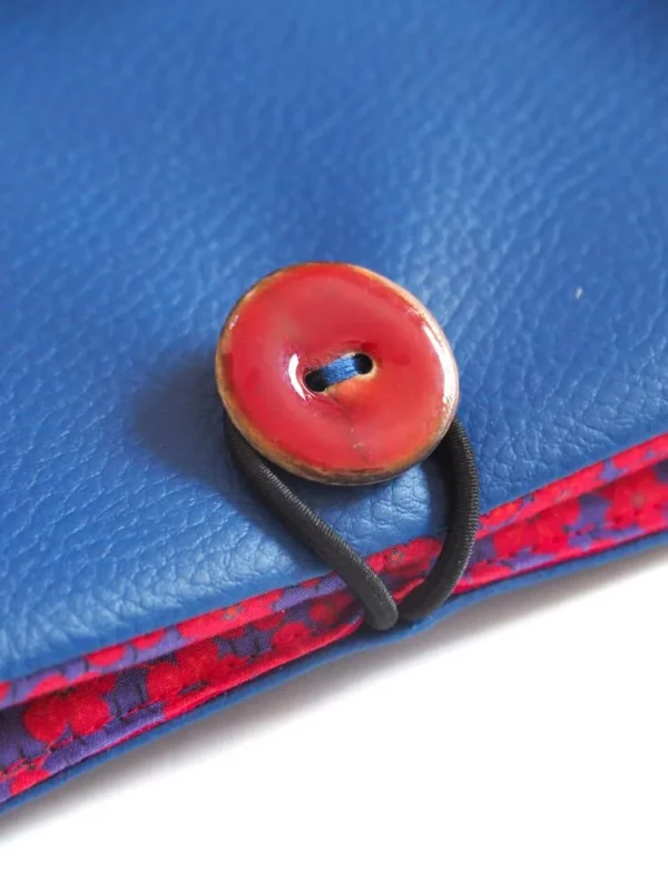 portefeuille simili cuir bleu tissu imprimé fleur gros plan bouton rouge