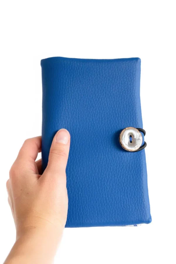 Portefeuille Picassa tenu dans la main simili cuir bleu bouton gris