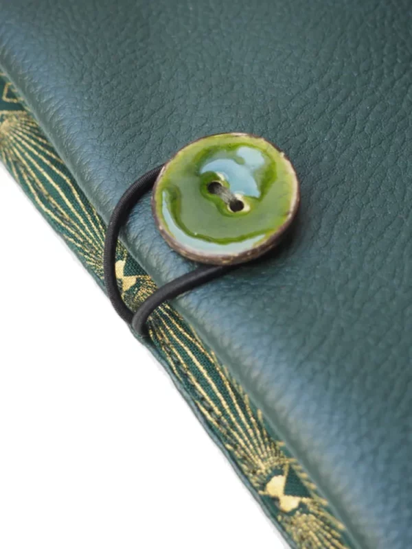 Portefeuille femme vert et doré zoom sur bouton coco vert