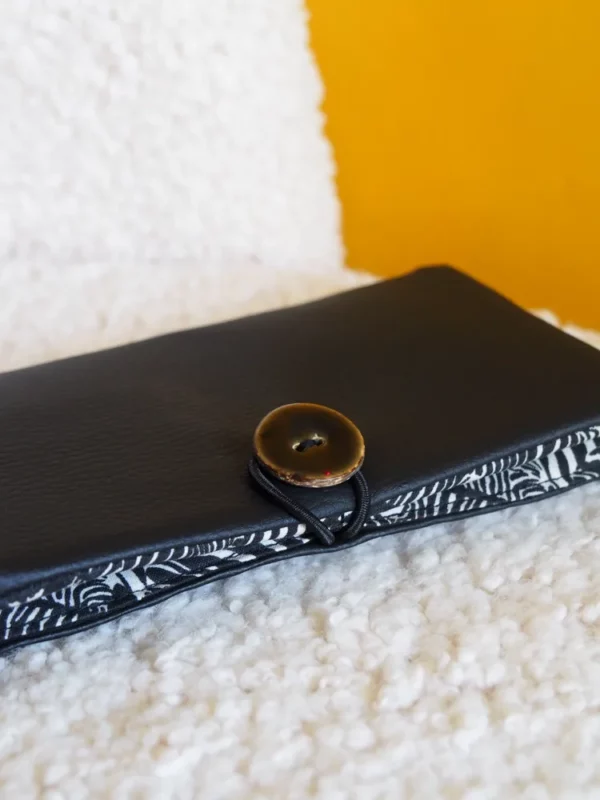 Portefeuille noir fermé zoom sur le bouton en coco noir