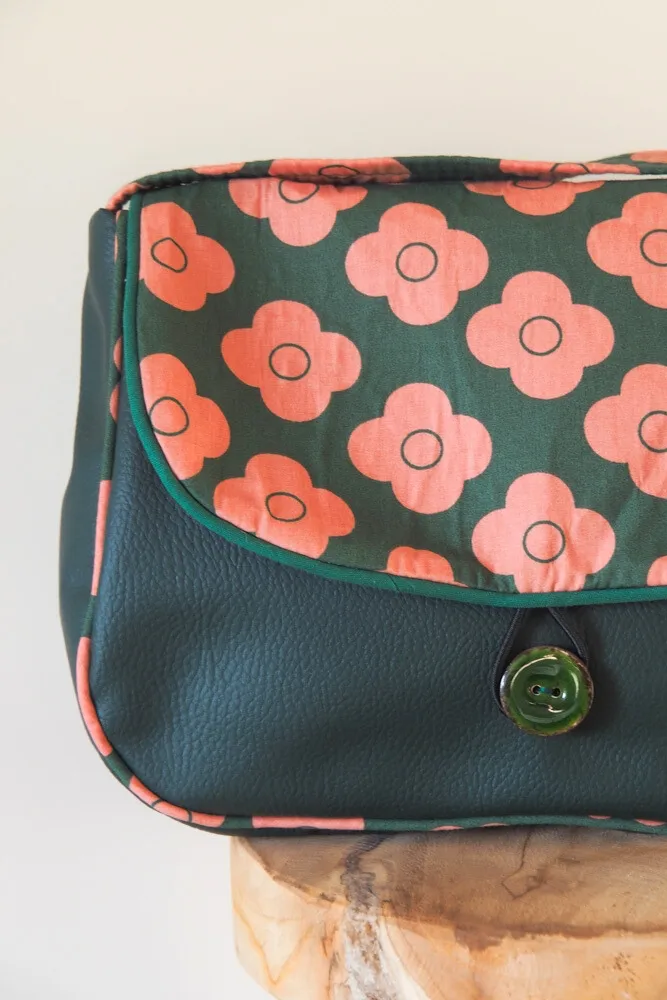 Gros plan sur le rabat du sac réversible Pimprenelle en tissu coton fleuri corail.