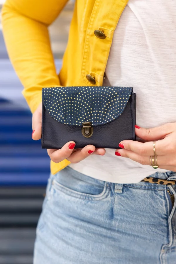 Porte-monnaie bleu nuit femme Céleste porté en extérieur, style artisanal élégant.