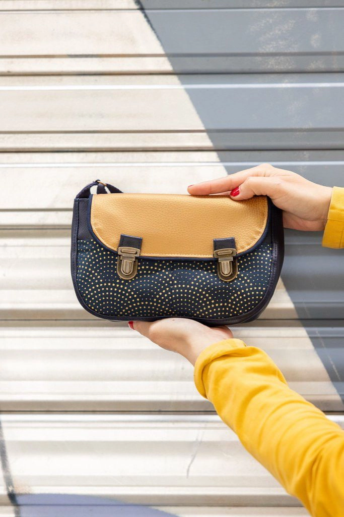 Sac artisanal bleu nuit et doré présenté dans les mains, modèle Céleste cousu main